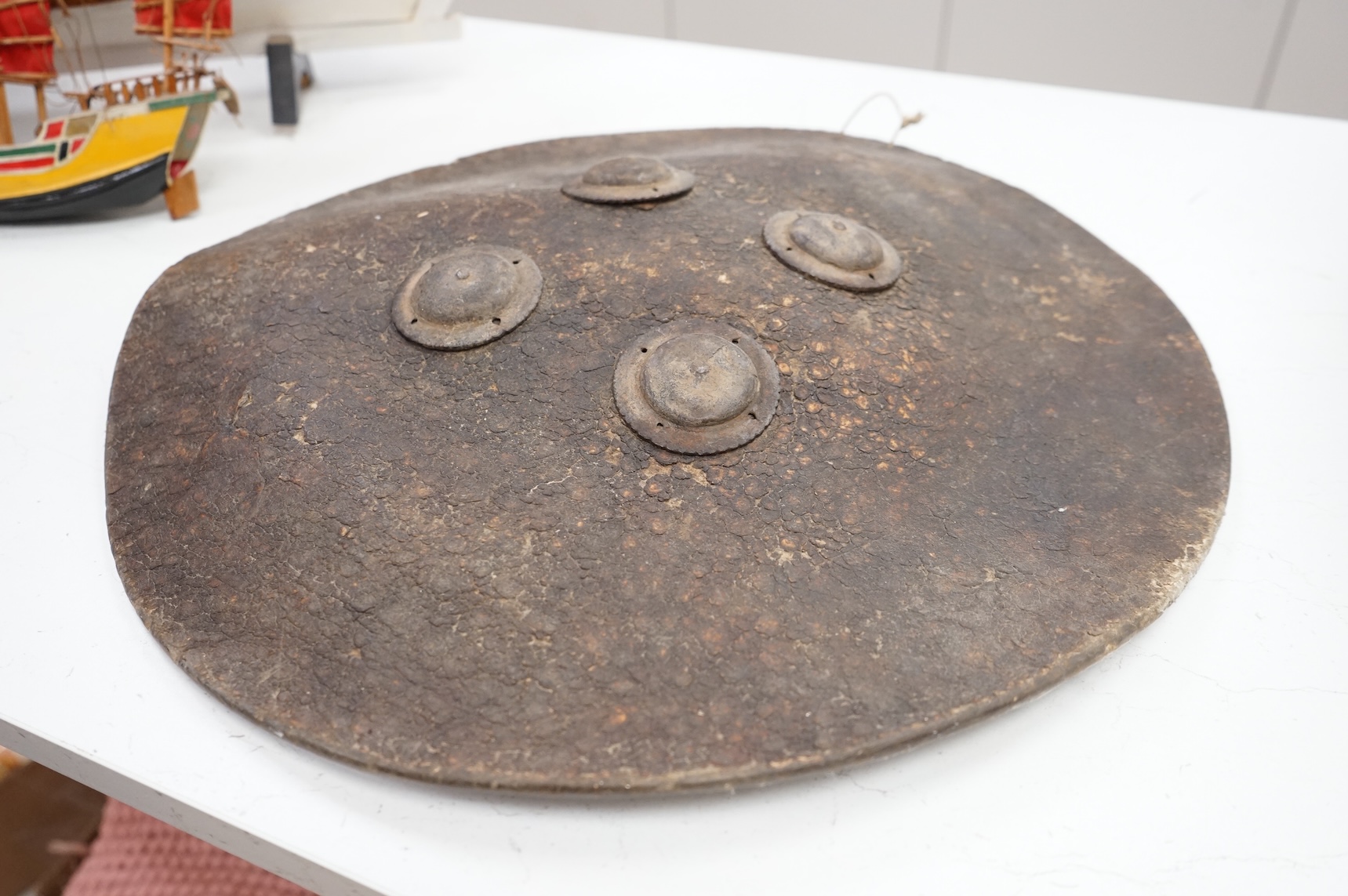 An Indian hide shield or dhal with four roundels, 47cm in diameter